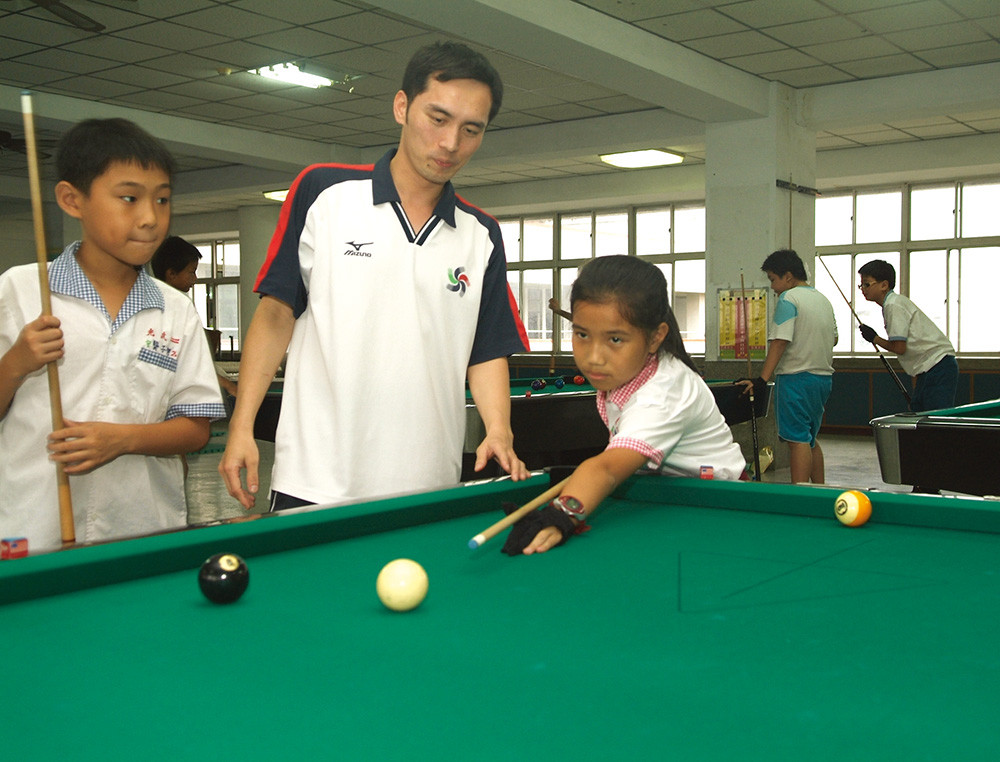  Hui-Kai Hsia, one of the best billiards players in Taiwan, devotes himself to this training program at Guang Wu Elementary School. 