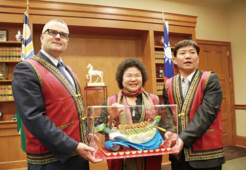 Mayor Chen Chu (center) presented two dragon boats to Portland Mayor Sam Adams (left).