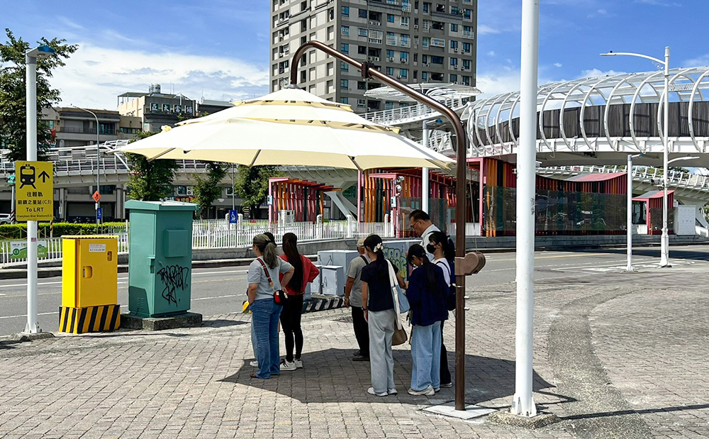 考量高雄夏季炎熱且高運量轉乘點等車市民眾多，選以具備高度機動性、能快速裝卸與收摺的人工遮陰設施先行試辦，在烈日下撐起貼心的通勤防護罩。
(圖片提供/高雄市政府捷運工程局)
