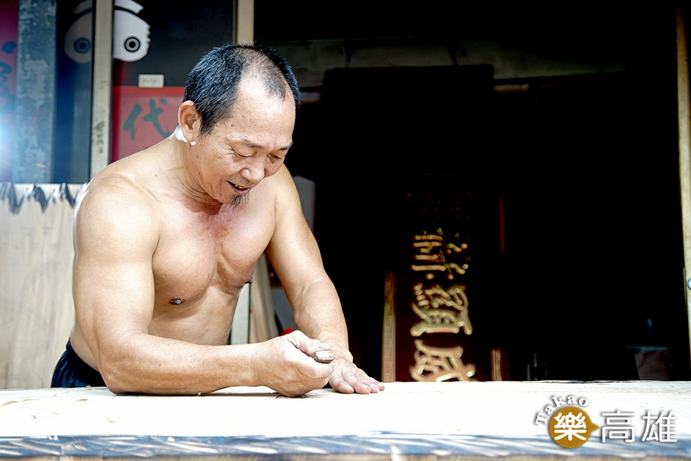 打赤膊製作匾額的吳崑章，是鳳山佛具街「三民路」生活裡的一道日常風景。（攝影/曾信耀）