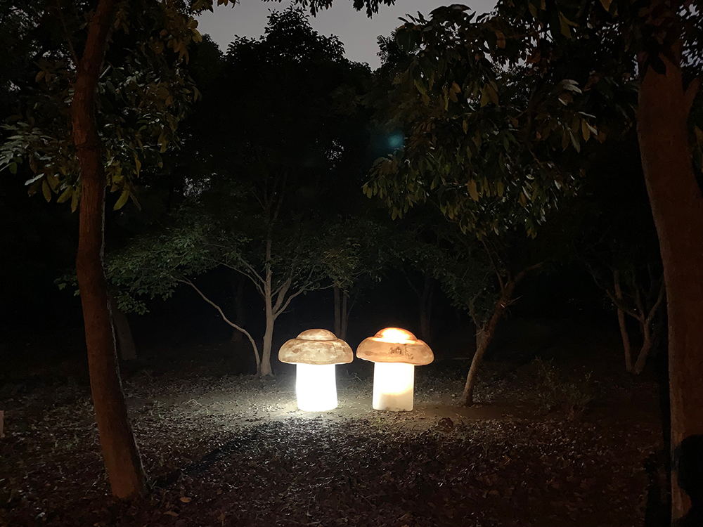 高市府團隊融入衛武營公園的森林元素，以樹影為背景，仿真蕈菇、微光花叢藏身其中，創造黑森林裡的藝術驚喜，圖為作品「蘑菇」。(圖片提供/高雄市政府觀光局)