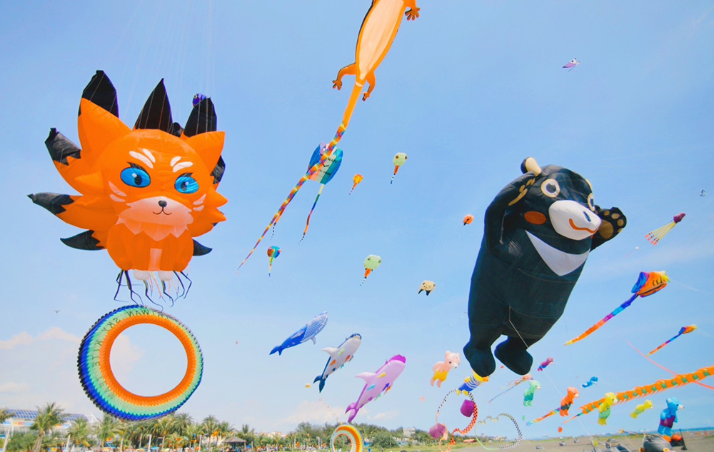 12米高雄熊軟Q的在空中擺動，與日本超人氣熊本熊串型風箏、色彩繽紛的七彩熊等攜手飛上天，十分可愛吸睛。(上：攝影/Carter；下：圖片提供/高市府觀光局)