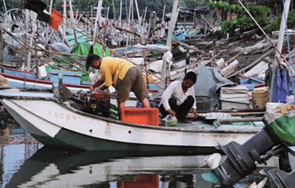 捕魚郎辛勤的準備魚具，是早期紅毛港普遍可見的畫面。(圖/黃明輝提供)