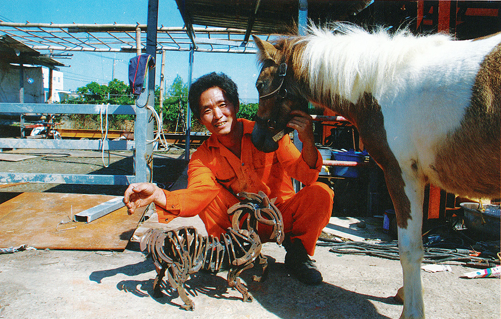 用馬蹄鐵焊成的鐵馬，和真的馬在一起，栩栩如生。（圖/郭力睿攝）