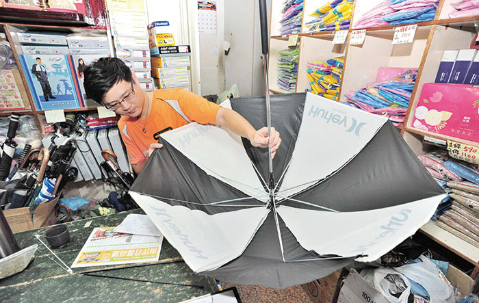 檢視傘況 Examining a broken umbrella