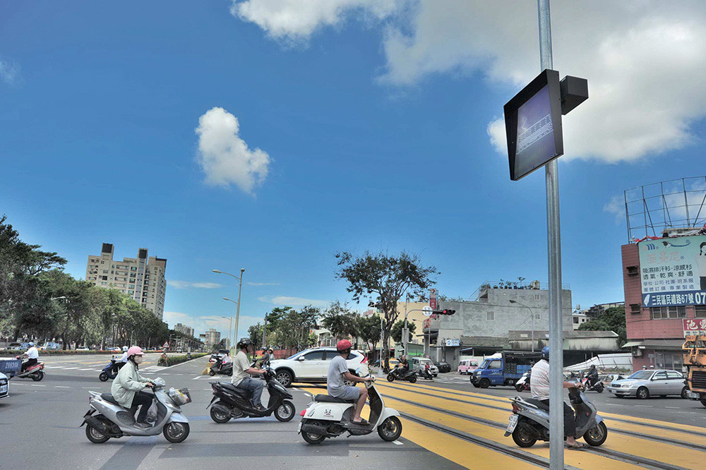 輕軌行經與一般道路共用交叉路口，輕軌行駛範圍內地面繪製黃色警示區域，請用路人行經黃線區禁止停留，應儘速通過。 The light rail shares the road with other veh