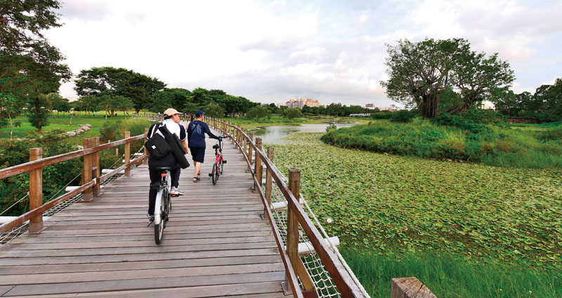 沿著自行車道，遊客漫步或騎乘自行車賞遊沿途景觀 Visitors walking and cycling along its bike paths