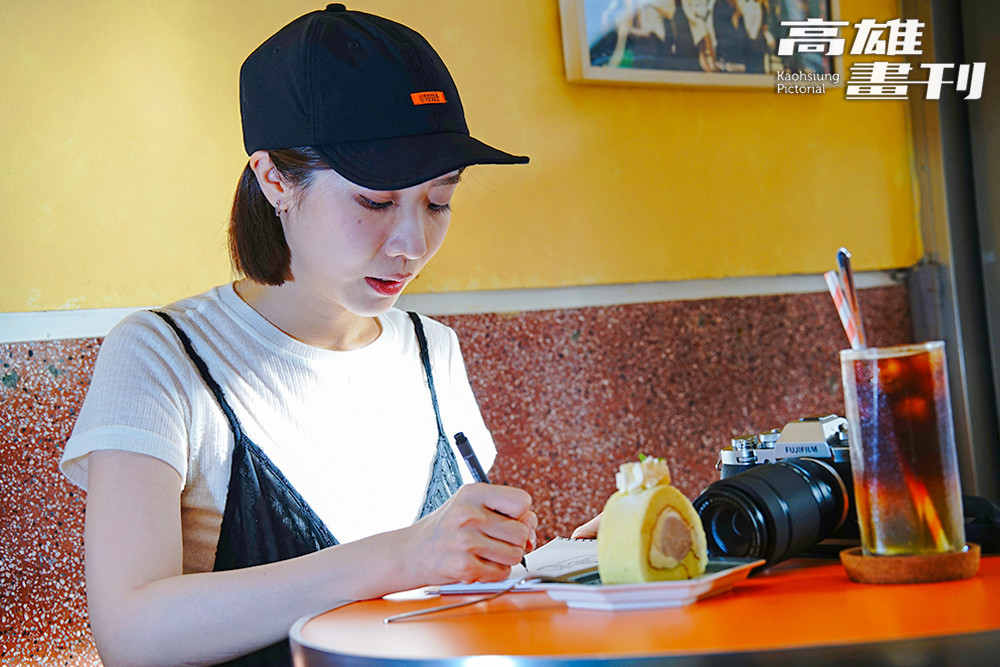 午後時分，歐佩玲坐在窗邊，陽光灑在桌上那一抹綠與紫的甜點上，成了一幅溫柔的日常風景。(攝影/曾信耀)