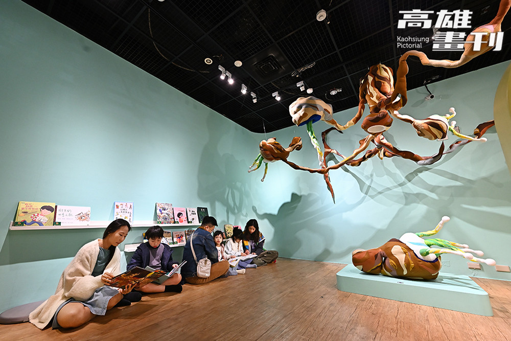 巨大花生下，親子席地共讀繪本，讓看展覽過程中也能有溫馨的親子時光。(攝影/Carter)