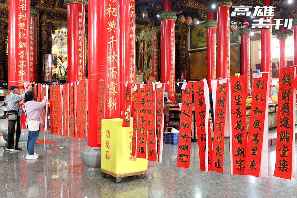 領完剛寫好的春聯，須仔細掛好晾乾，廟內滿是萬年紅一片，映出對來年的期待。(攝影/Carter)