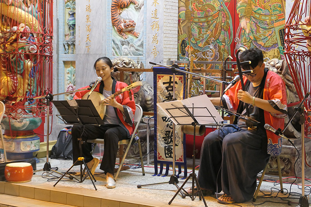 陳珍儀在無水寮商展廟埕音樂會緩緩撥弄琴弦，以悠揚的歌聲唱出文史。（圖片提供/莊毅冠