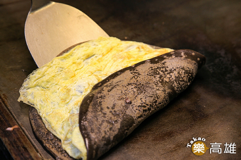 粉漿蛋餅做法是將麵糊在鐵板上煎得表皮焦香，再包入內餡捲起。（攝影/李瑰嫻）
