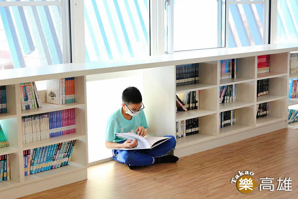 孩子們很喜歡在木板平台上看書，一個人窩在城垛書櫃的秘密基地，安靜地閱讀。（攝影/Carter）