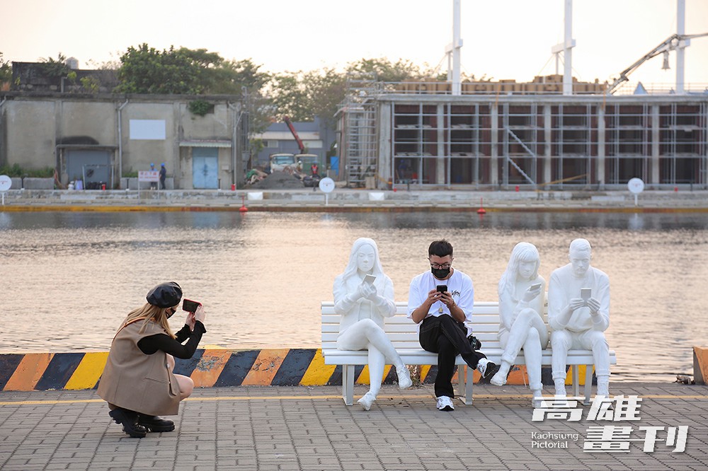 「手機人生」長椅上出現低頭滑手機的人型塑像，作品中間的空位，邀請觀眾走入作品，成為藝術的一部分。(攝影/Carter)